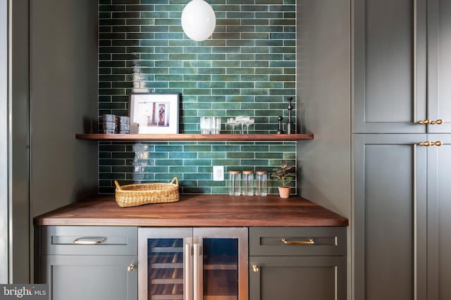 indoor dry bar featuring beverage cooler and backsplash