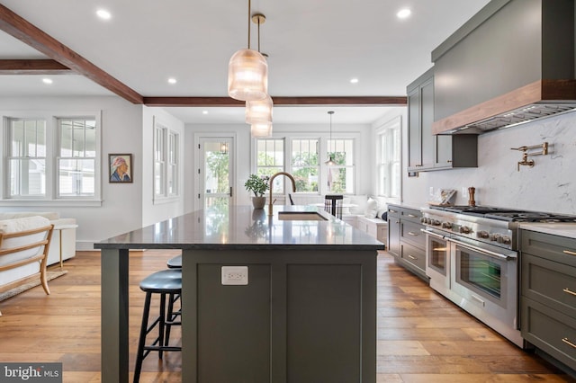 kitchen featuring double oven range, custom exhaust hood, a sink, beam ceiling, and recessed lighting