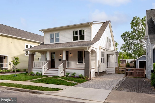 view of front of home featuring a porch, a shingled roof, and a gate