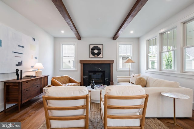 living room with wood finished floors, beamed ceiling, a fireplace, and recessed lighting