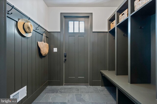 mudroom featuring a wainscoted wall and wood walls