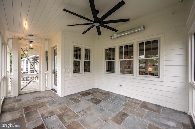 unfurnished sunroom featuring ceiling fan