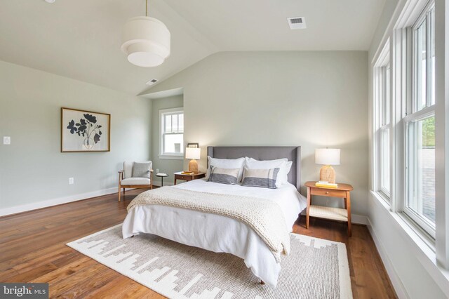 bedroom featuring wood finished floors, baseboards, and vaulted ceiling