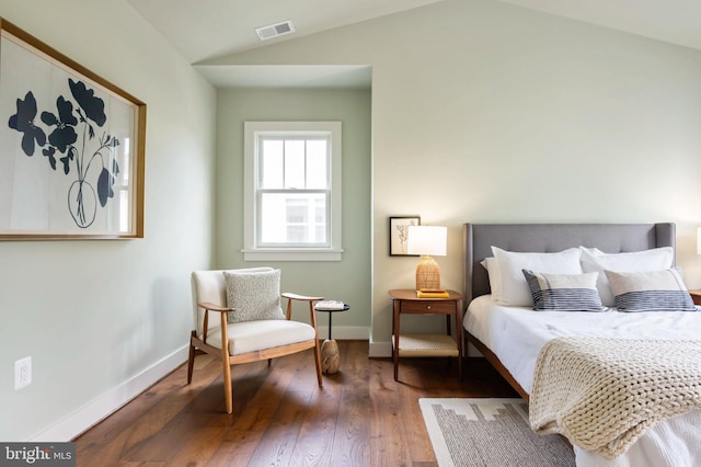 bedroom with lofted ceiling, dark wood-style floors, and baseboards