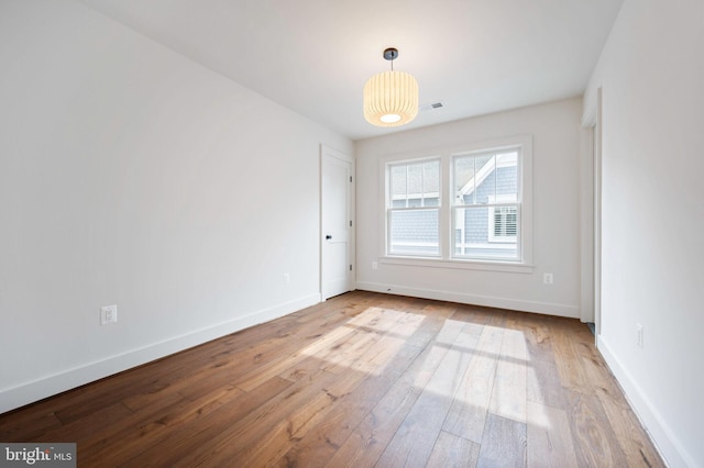 empty room with hardwood / wood-style flooring and baseboards