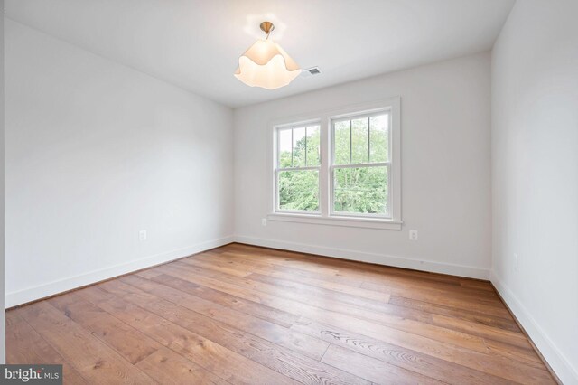 unfurnished room featuring baseboards and light wood-style flooring