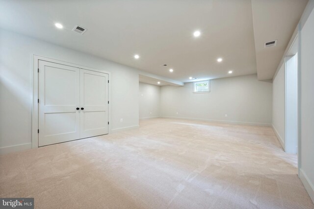 below grade area featuring recessed lighting, light colored carpet, and baseboards