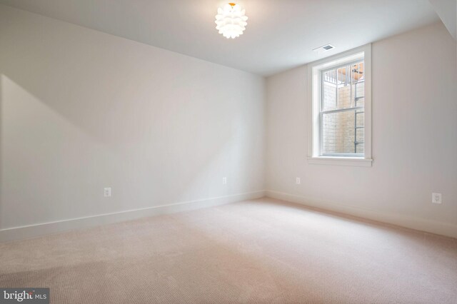 carpeted spare room featuring baseboards