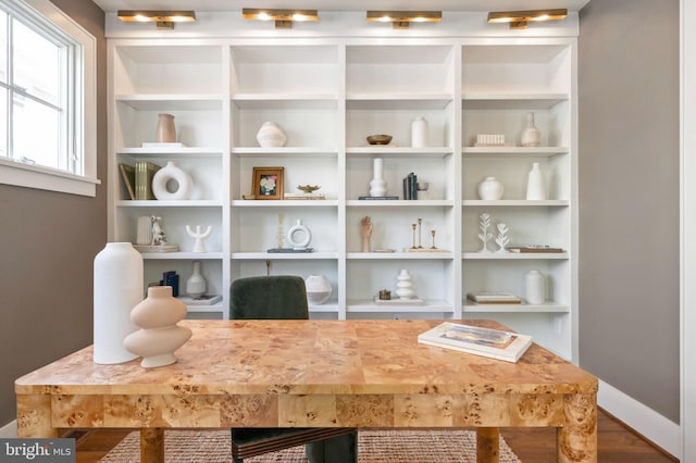 home office with baseboards and wood finished floors