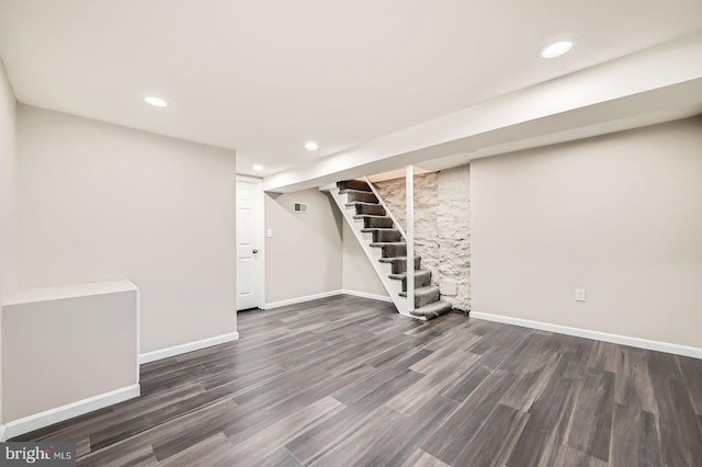 finished below grade area featuring baseboards, recessed lighting, wood finished floors, and stairway