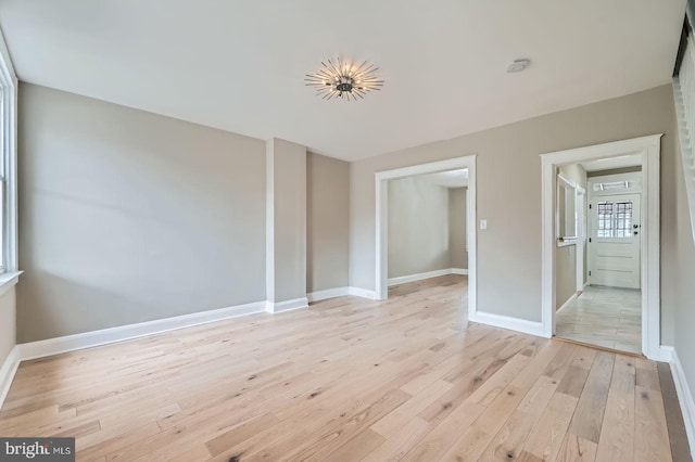 unfurnished room with light wood finished floors and baseboards