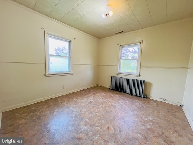 unfurnished room with crown molding, visible vents, plenty of natural light, and radiator heating unit