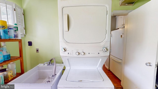 6103 Manor Rd, Clinton, MD 20735 - laundry area featuring stacked washer / dryer, a sink, and dark wood-type flooring