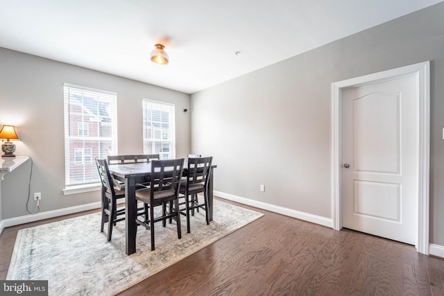 dining space with dark wood-style floors and baseboards