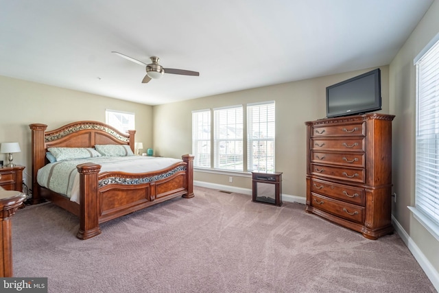 bedroom with light colored carpet, baseboards, a ceiling fan, and visible vents