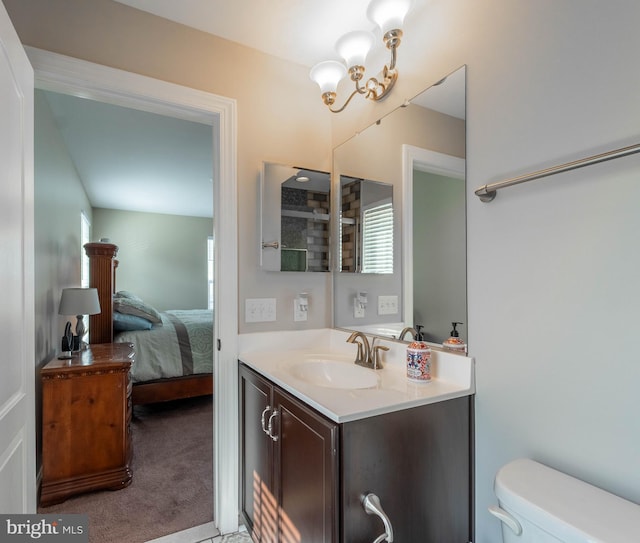 bathroom featuring toilet, vanity, ensuite bathroom, and an inviting chandelier