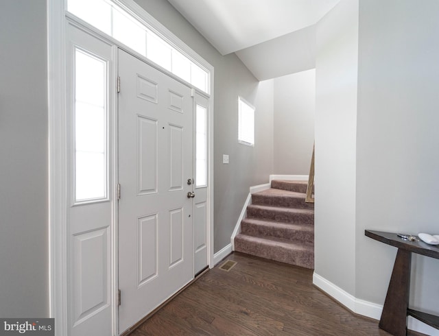 entrance foyer with stairs, dark wood-style floors, baseboards, and visible vents