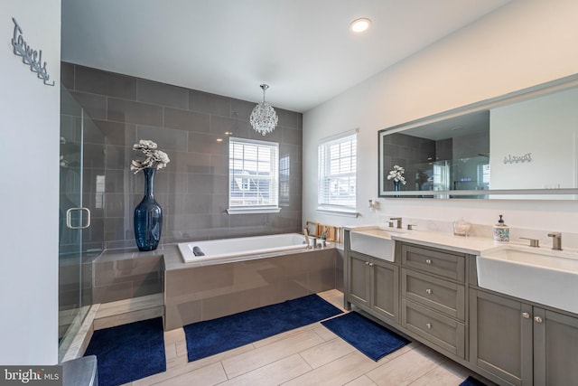 full bath with a sink, a notable chandelier, and a stall shower