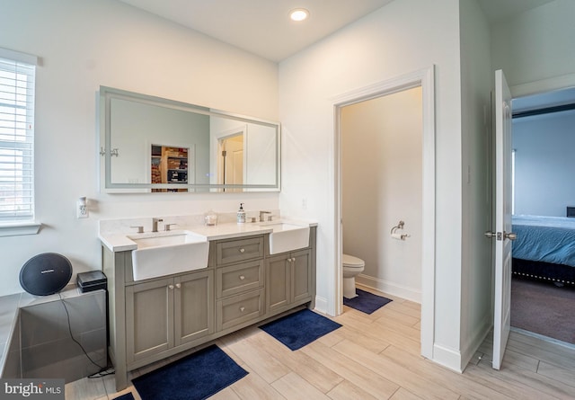 full bath featuring a wealth of natural light, toilet, a sink, and connected bathroom