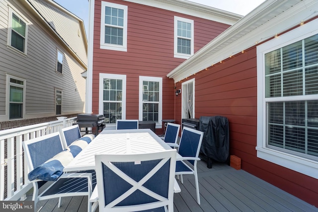 wooden terrace featuring grilling area and outdoor dining area
