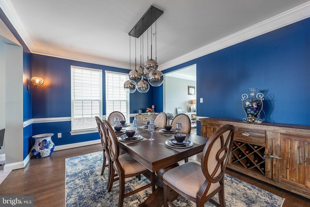 dining area featuring a chandelier, wood finished floors, baseboards, and ornamental molding