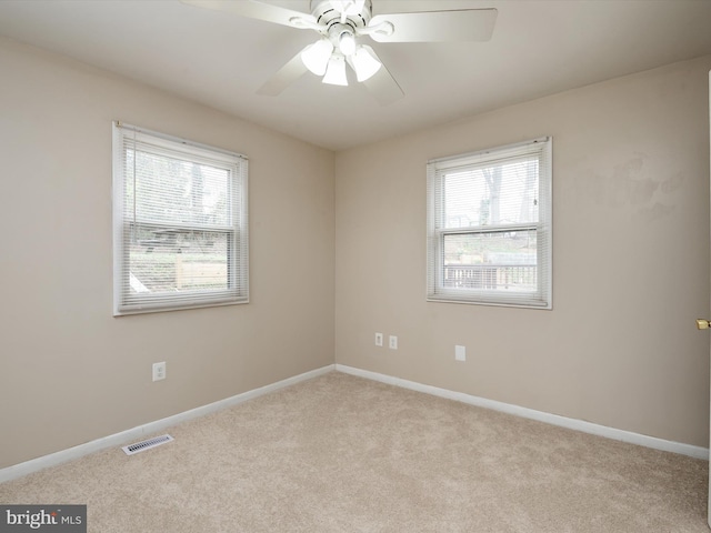 unfurnished room featuring carpet, visible vents, baseboards, and ceiling fan