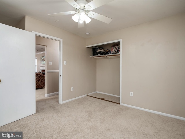 unfurnished bedroom featuring carpet flooring, a closet, baseboards, and a ceiling fan