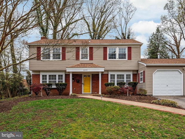 view of front facade with a front yard, an attached garage, brick siding, and aphalt driveway