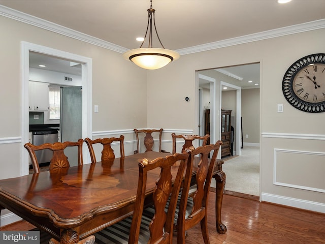 dining space with wood finished floors, baseboards, ornamental molding, and recessed lighting