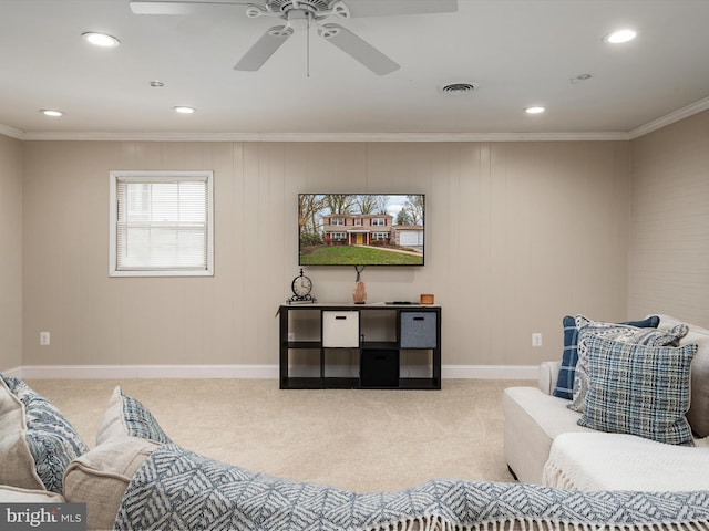 living area with visible vents, ceiling fan, ornamental molding, and carpet floors