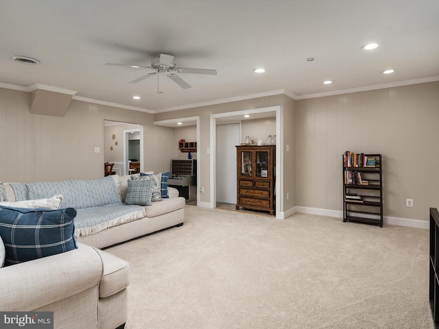 living room with visible vents, baseboards, ornamental molding, a ceiling fan, and light colored carpet