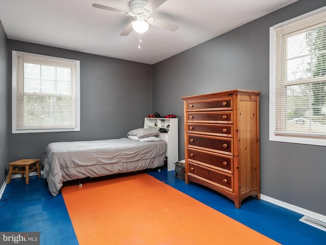 bedroom featuring ceiling fan, baseboards, multiple windows, and visible vents