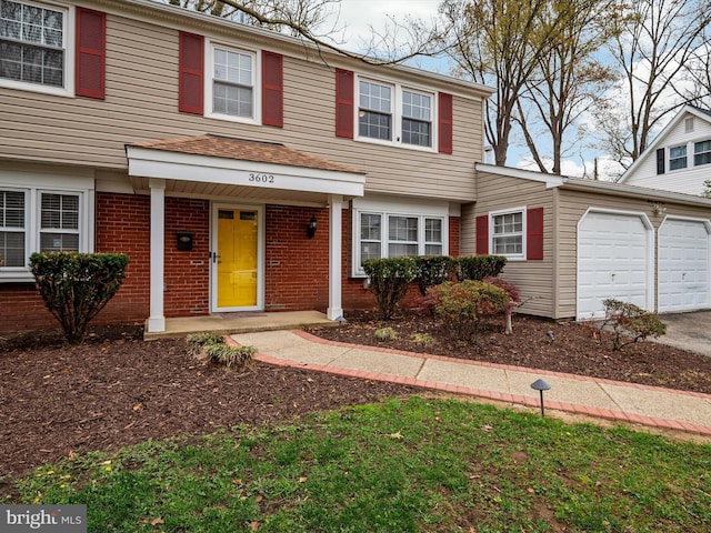 view of front of property featuring a garage, concrete driveway, and brick siding