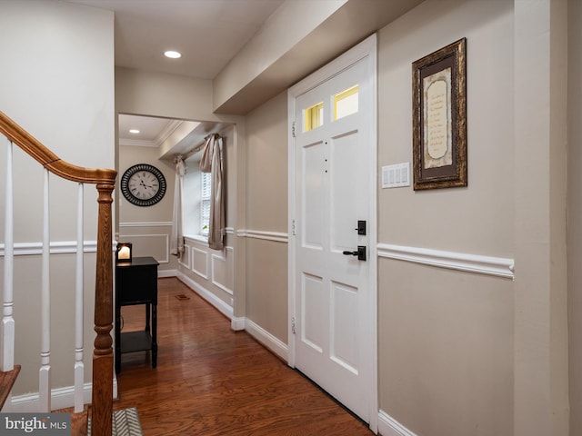foyer entrance with recessed lighting, crown molding, stairs, a decorative wall, and wood finished floors