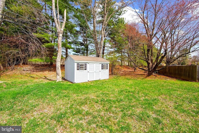 view of yard with a storage shed, an outdoor structure, and fence