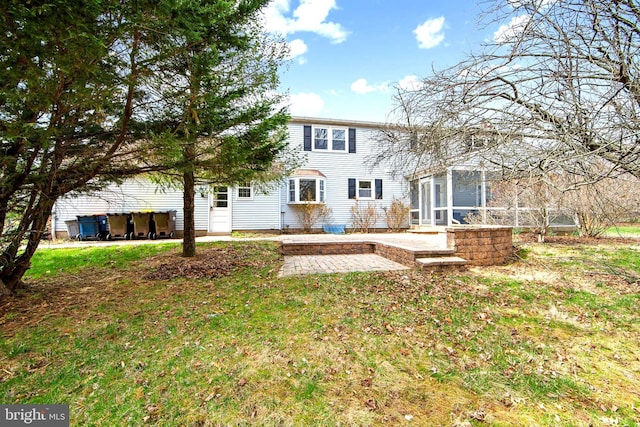 rear view of property with a patio and a lawn