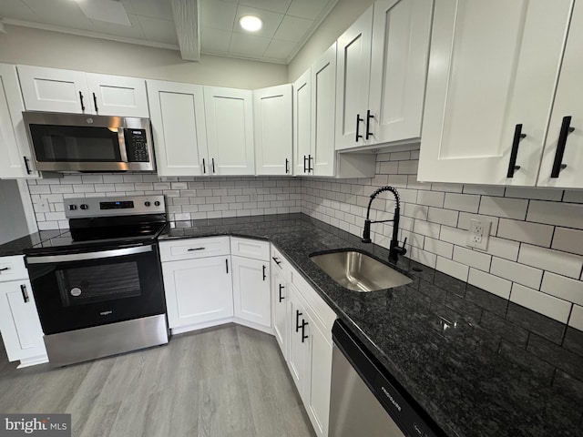 kitchen featuring white cabinetry, light wood-style flooring, a sink, and stainless steel appliances