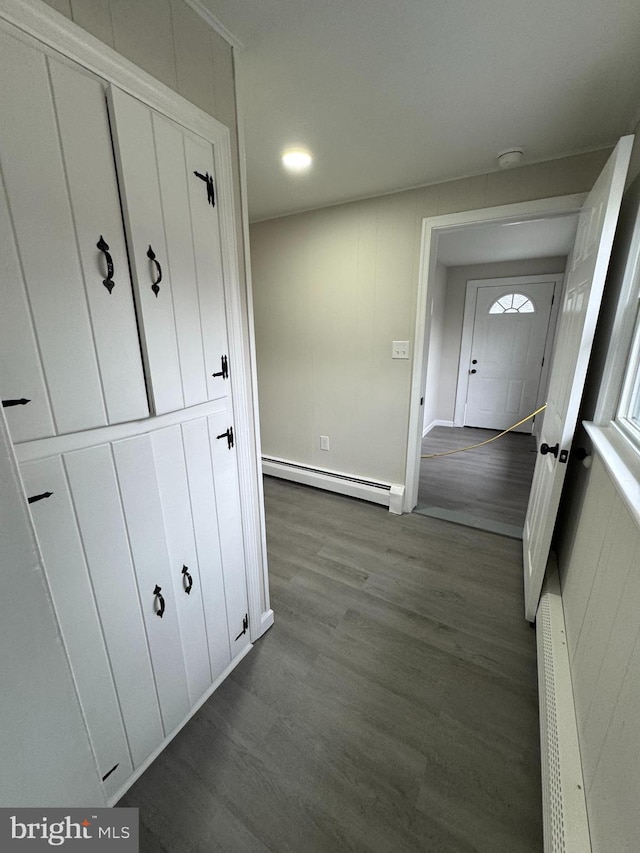 corridor with dark wood-style floors and baseboard heating