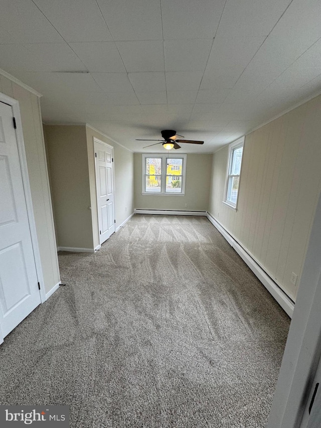 interior space featuring a baseboard heating unit, carpet flooring, baseboards, a ceiling fan, and baseboard heating