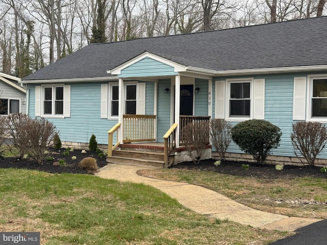 view of front of property featuring a shingled roof, a front lawn, and a porch