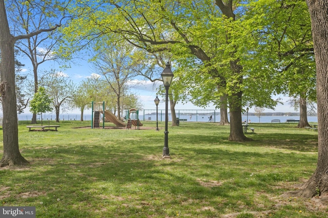 view of yard with playground community and a water view