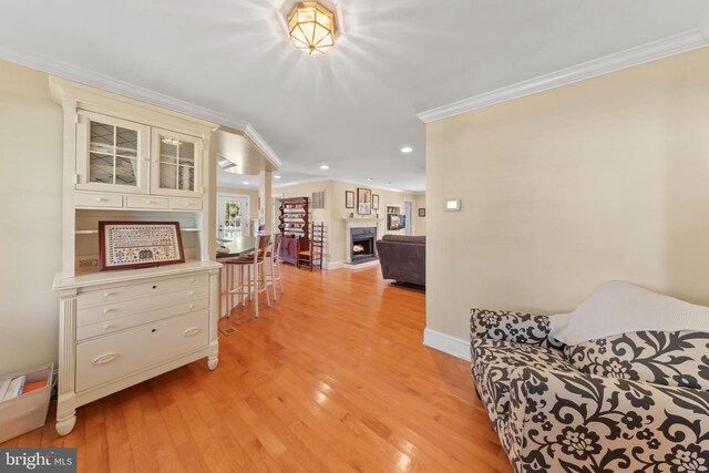 hallway with recessed lighting, light wood-style floors, and ornamental molding