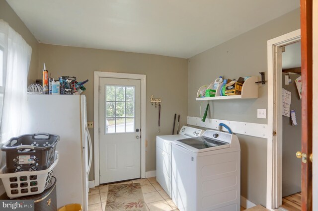 laundry room with separate washer and dryer, light tile patterned floors, and laundry area