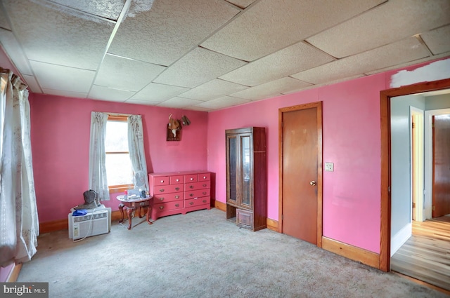 unfurnished bedroom featuring carpet floors, baseboards, and a paneled ceiling