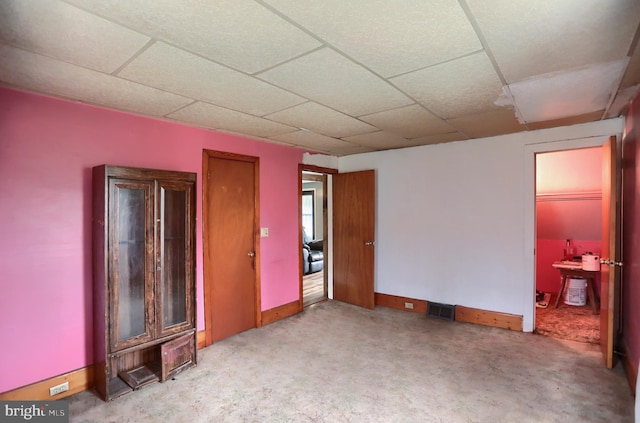 unfurnished room with baseboards, visible vents, and a drop ceiling
