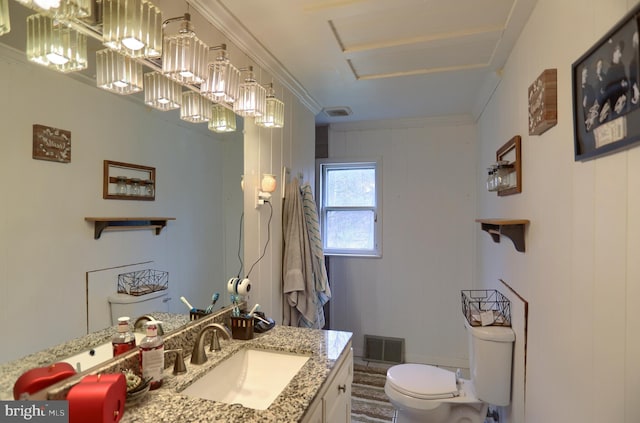 bathroom with toilet, vanity, ornamental molding, and visible vents