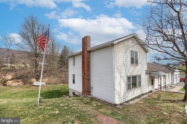 view of home's exterior featuring a chimney and a yard