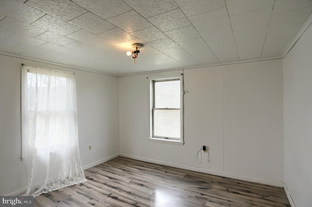 unfurnished room featuring baseboards and wood finished floors