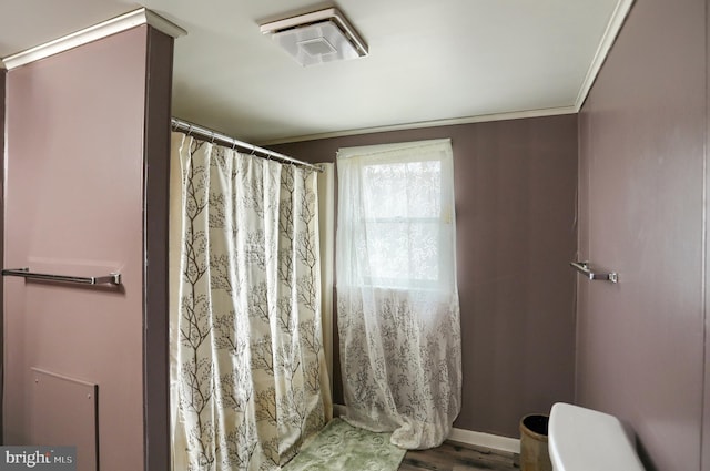 bathroom featuring toilet, a shower with curtain, baseboards, visible vents, and ornamental molding