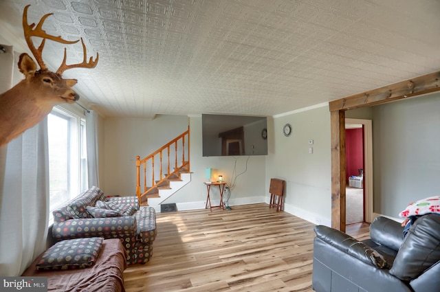 living room featuring baseboards, stairs, and wood finished floors